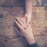 Man and woman holding hands at a table